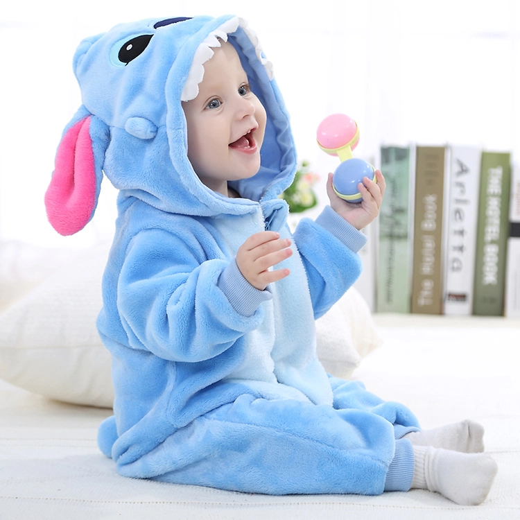 Dette billede viser et blødt og behageligt lyseblåt Stitch-kostume til børn, udformet som en heldragt med en hvid mave og en detaljeret hætte. Hætten har store, karakteristiske ører og et broderet ansigt, der gør udklædningen perfekt til både leg og fastelavn.