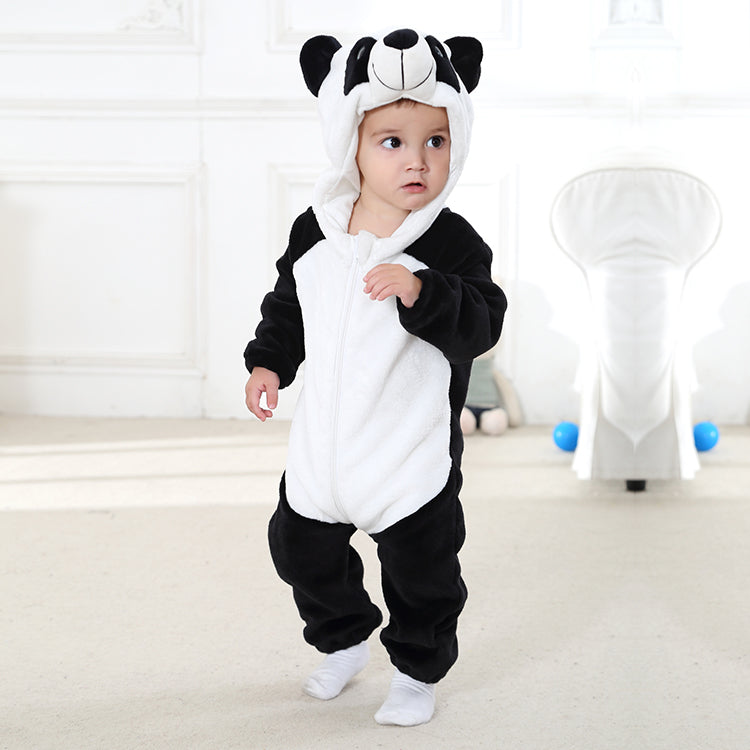 Billedet viser et nuttet og blødt panda-kostume til børn i klassiske sorte og hvide farver. Denne heldragt har en hvid mave og sorte ærmer samt ben, og den er udstyret med en integreret hætte, der forestiller et pandaansigt med små ører og mørke markeringer omkring øjnene, hvilket gør den ideel til sjov udklædning eller fastelavn.
