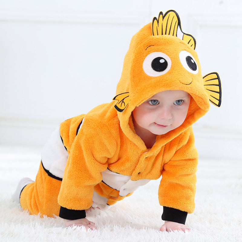 Dette billede viser et charmerende Nemo-kostume til børn, formet som en klovnfisk i klare orange og hvide farver. Dragten er lavet af blødt flannelmateriale og har en polstret hætte med store øjne og finner, der skaber et livagtigt og nuttet udseende til fastelavn eller leg.