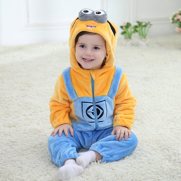 Et farverigt Minion-kostume til børn lavet af blødt, gult og blåt flannel. Dragten har de klassiske denim-overalls detaljer, en hætte med et stort øje og briller samt små hår på toppen, hvilket gør den perfekt til leg og fastelavn.