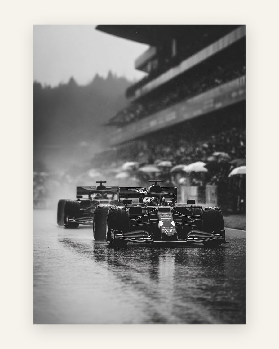 Sort-hvidt motiv med to Formel 1-racere i regnvejr på våd bane med tilskuere under paraplyer