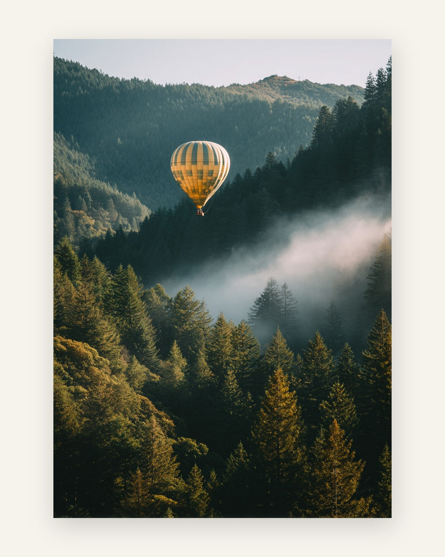 Fotografisk plakat med gul-cremestribet varmluftballon der svæver over en tåget, grøn nåleskov med bjerge