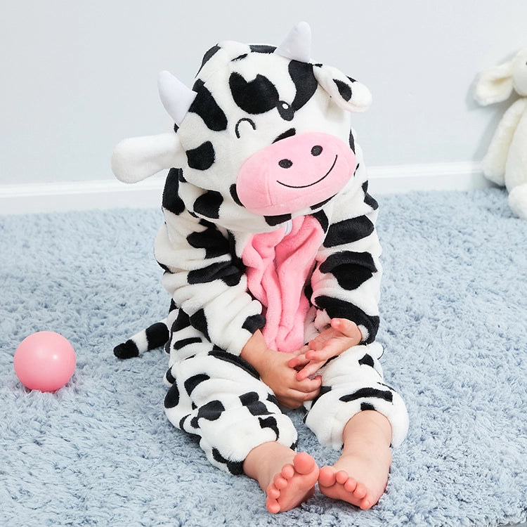 Dette billede viser et nuttet og blødt ko-kostume til børn, lavet af hvidt flannel med sorte pletter. Dragten har en lyserød mave, en lille hale og en hætte med et sødt ko-ansigt, ører og små horn, perfekt til leg eller fastelavn.