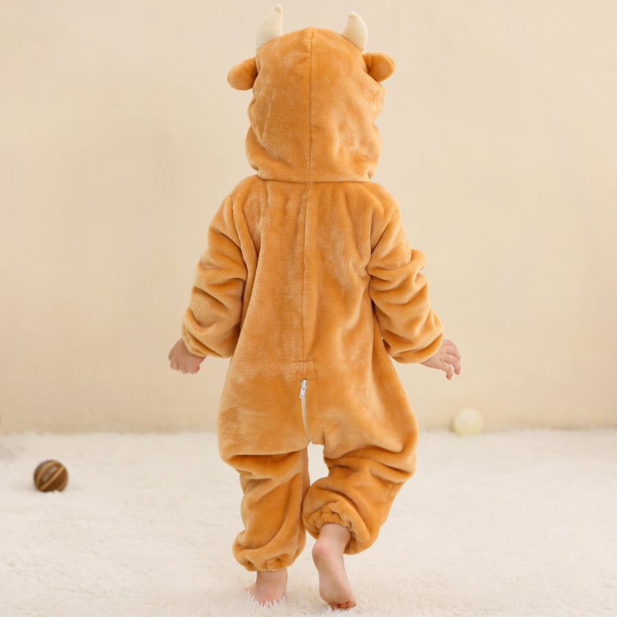 Et blødt og behageligt tyrekostume til børn i brun flannel. Dragten har en hvid mave, en sød hætte med horn og ører samt en lille hale bagpå, hvilket gør den perfekt til både leg og fastelavn.