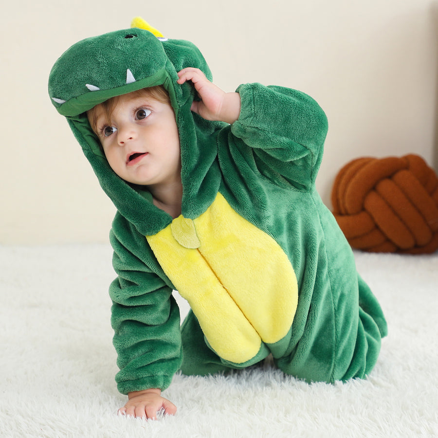 Et nuttet og blødt grønt T-Rex dinosaurkostume til børn, der vises fra siden. Dragten er lavet af behageligt flannelmateriale med takkede rygskjold, en lang hale og en hætte med øjne og tænder, perfekt til leg eller fastelavn.