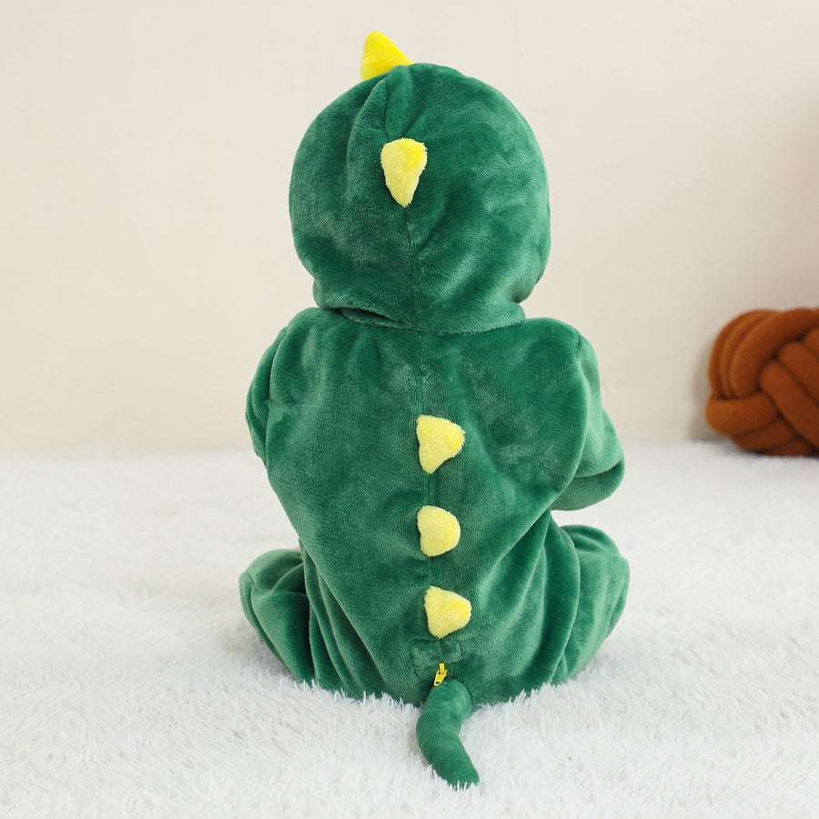 Et billede af et grønt T-Rex kostume til børn, der vises fra siden. Kostumet er lavet af blødt materiale med takkede detaljer langs ryggen og en lang hale, hvilket skaber et sjovt og gennemført dinosaur-look til leg eller fastelavn.