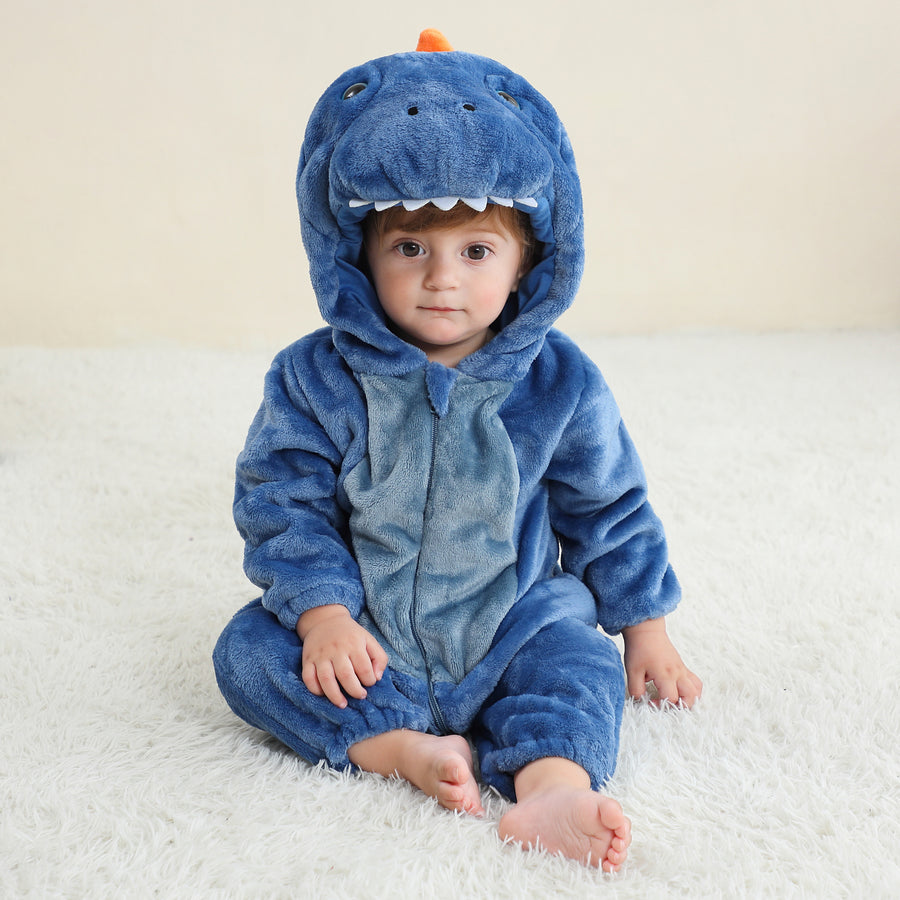 Billedet viser et charmerende og blødt blåt T-Rex kostume til børn, set fra siden. Dragten er lavet af vamset flannel med en hvid mave, takker langs ryggen og en matchende hætte med et sødt dinosauransigt, hvilket gør den ideel til både leg og fastelavn.