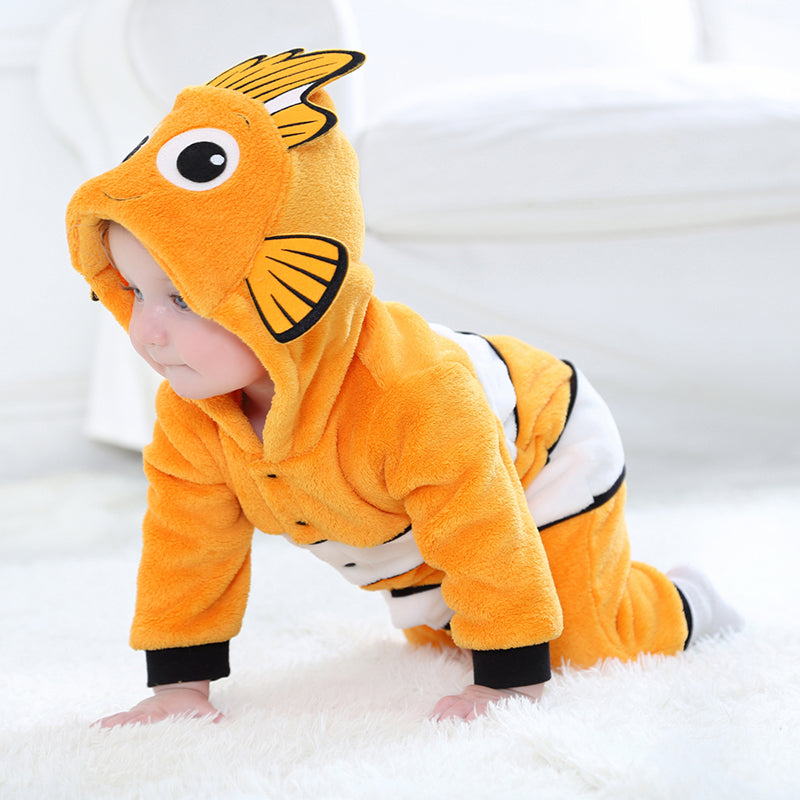 Et charmerende og blødt klovnfiskekostume til børn, der er inspireret af Nemo. Dragten er orange med hvide og sorte striber, har en sød hætte med store øjne og små finner på siderne. Den bløde flannel gør den perfekt til både udklædning og leg.