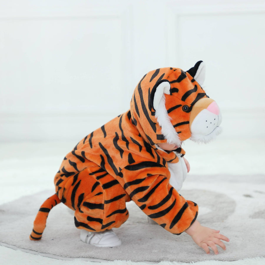 Dette billede viser et nuttet og blødt orange tigerkostume til børn, set bagfra for at fremhæve den lille hale. Dragten er lavet af plysset flannelmateriale med sorte striber og har en matchende hætte med små ører, hvilket gør den perfekt til leg eller fastelavn.