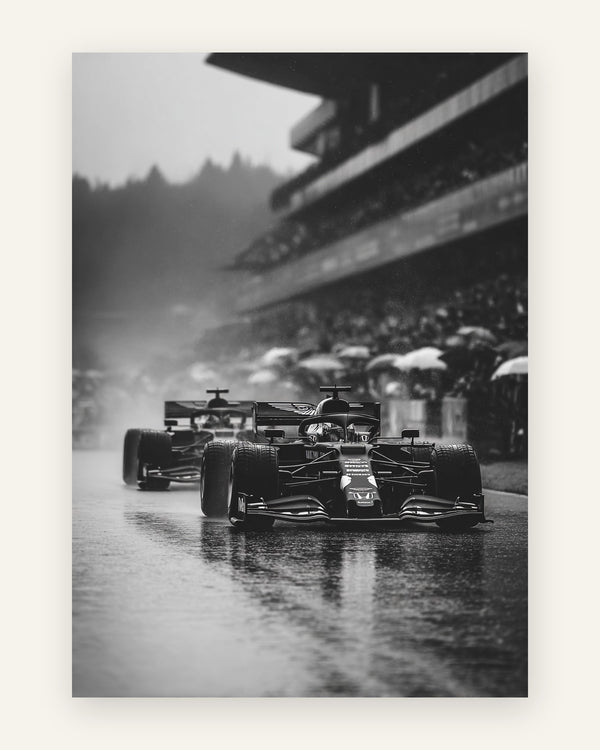 Sort-hvidt motiv med to Formel 1-racere i regnvejr på våd bane med tilskuere under paraplyer
