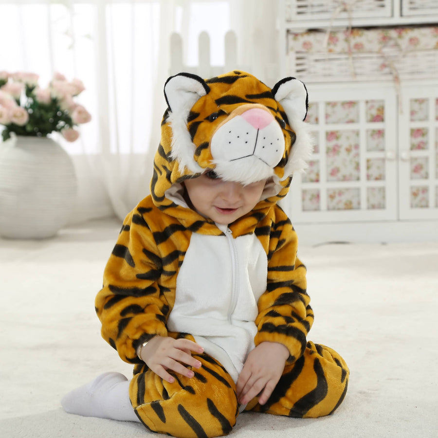 Et charmerende og blødt tigerkostume til børn, der er designet som en heldragt i orange med de klassiske sorte striber og en lys mave. Dragten har en fastgjort hætte med et sødt tigeransigt, små ører og en lang hale bagpå, hvilket gør den perfekt til leg eller fastelavn.