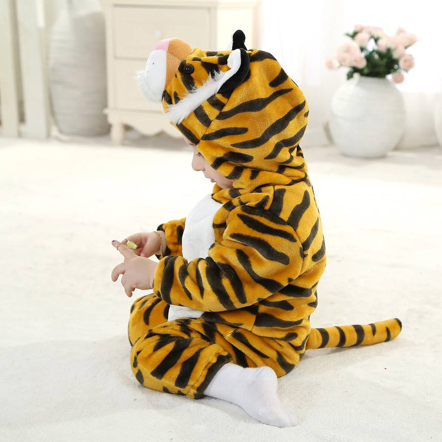 Et nærbillede af et nuttet tigerkostume til børn, der viser den bløde orange pels med sorte striber. Dragten har en detaljeret hætte med små ører, en hvid snude og klare øjne, hvilket skaber et sjovt og livagtigt udtryk til leg eller fastelavn.